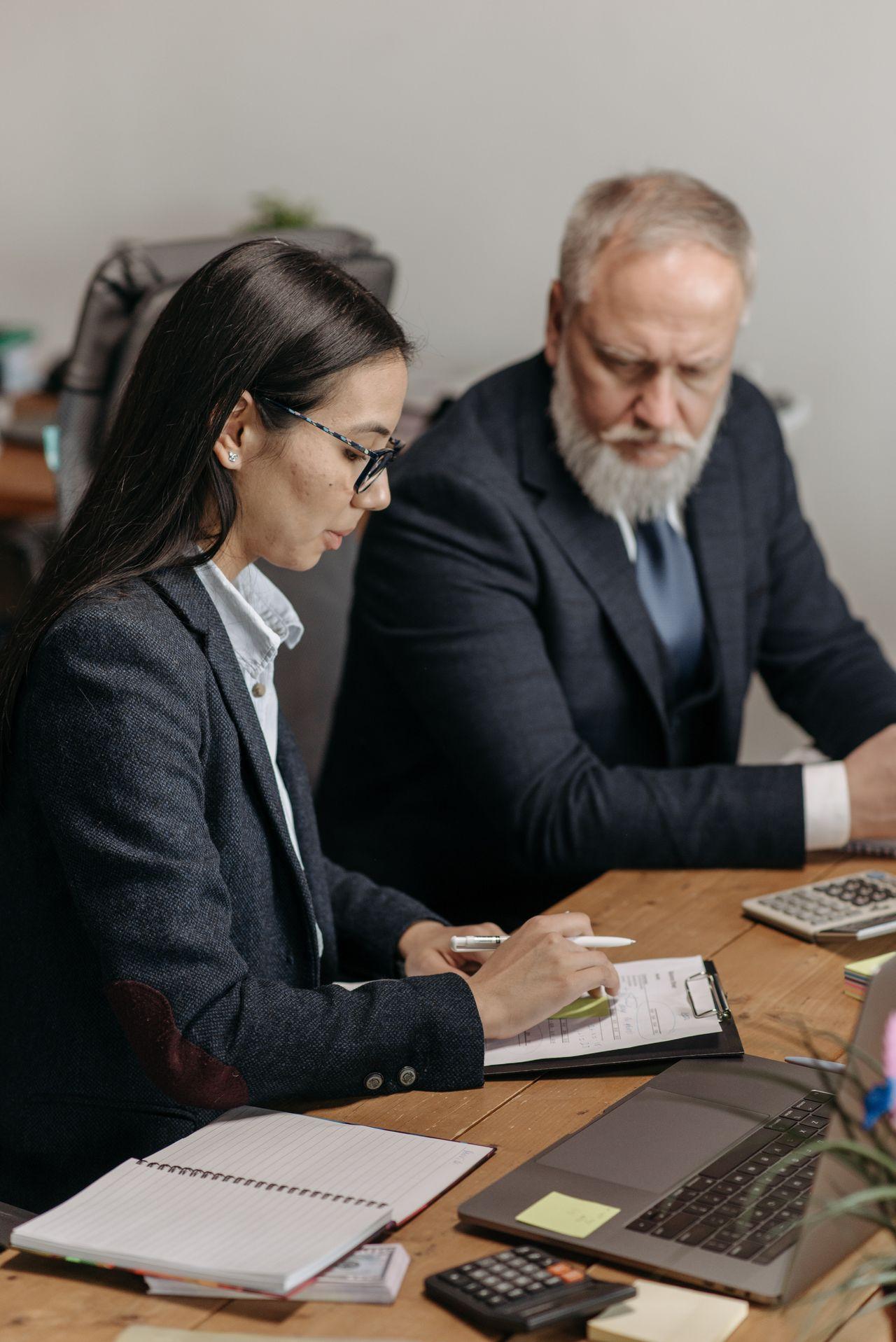 An HR adviser and business manager reviewing workplace documents together